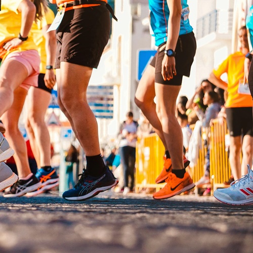 Biegacze w koszulkach biegowych przygotowują się do startu w zawodach